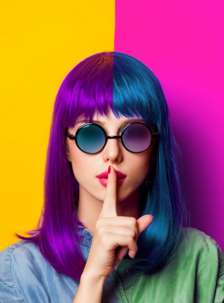 Young girl with purple hair and sunglasses Young girl with purple hair and sunglasses on yellow background multi coloured glasses stock pictures, royalty-free photos & images