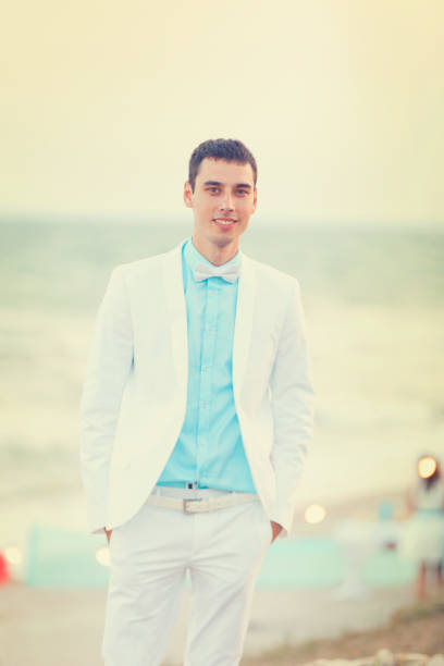 istock Young bridegroom in white clothes at sea cost 922721832