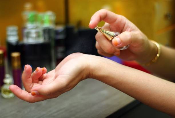 istock Young woman appliying perfume spray on her hand 922722486