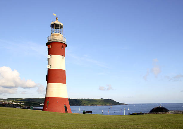 Beachy head lighthouse at the edge of white chalk cliff. Safety warning in the ocean.