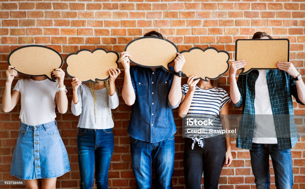 Young adults holding up copy-space placard thought bubbles Discussion Stock Photo