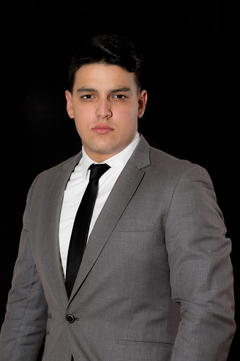 Young business businessman, standing against a white wall, in a suit