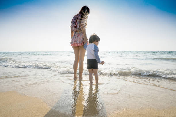 istock Mom walking on the beach with her son. 922732544