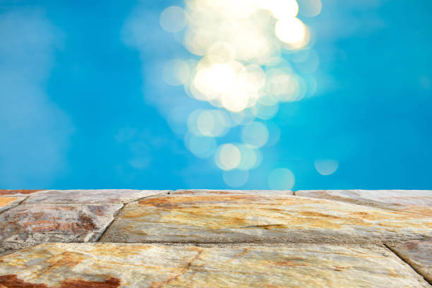 istock Brown stone table top and blurry blue water bokeh abstract background 922733046