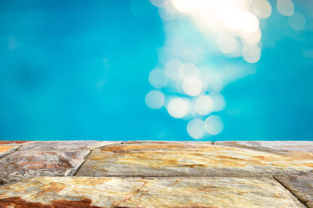 istock Brown stone table top and blurry blue water bokeh abstract background 922733048