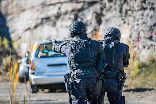 Swat Police Officers Shooting With Firearm and throwing a flash bomb.