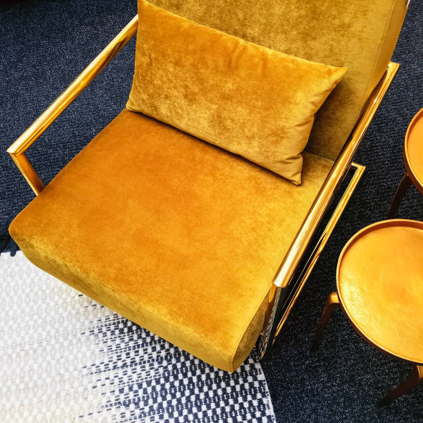 Retro style dark yellow velvet armchair and golden side table stock photo