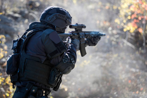 swat police officer shooting with firearm - police helmet imagens e fotografias de stock