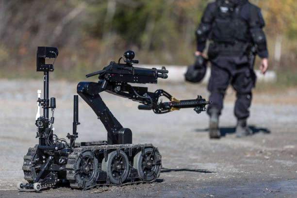police swat officer using a mechanical arm bomb disposal robot unit - police helmet imagens e fotografias de stock