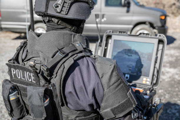 police swat officer using a mechanical arm bomb disposal robot unit - police helmet imagens e fotografias de stock