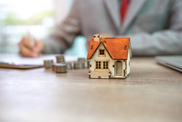 istock Businessman signs contract behind home architectural model 922735934