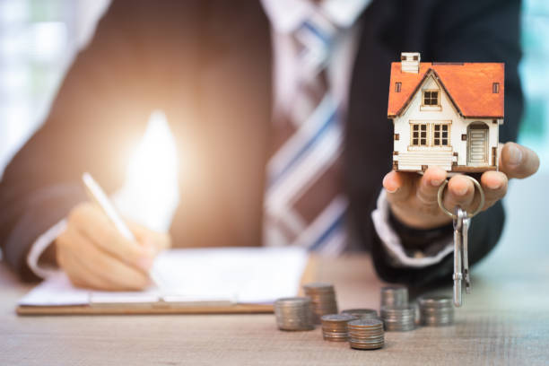 istock Businessman signs contract behind home architectural model 922735992