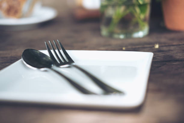 istock One set of spoon and fork in a white plate on vintage wooden table 922736364