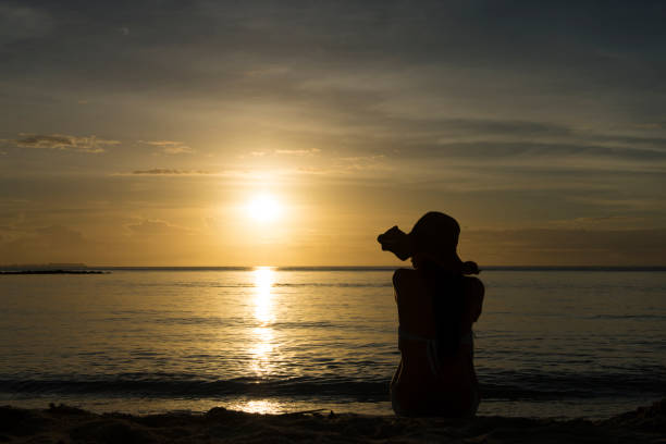 istock beautiful woman relaxing at the sunset beach 922738646