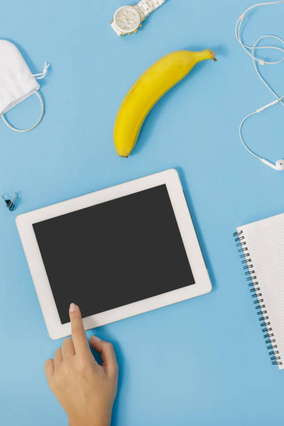 istock Top view white tablet with blank screen in female hands on blue background 922742442