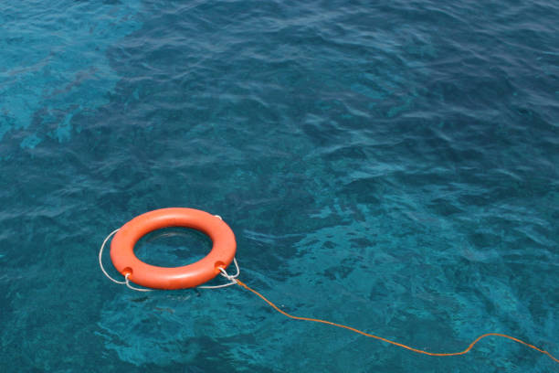 istock Orange Lifesaving ring floating on clear blue sea 92274270