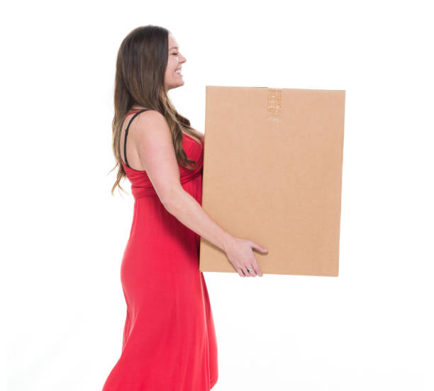 istock Cute female in red dress moving boxes 922743138