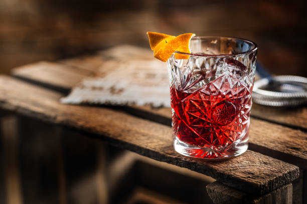 Cocktail Negroni on a old  wooden board. Drink with gin, campari martini rosso and orange Cocktail Negroni on a old  wooden board. Drink with gin, campari martini rosso and orange. whiskey photos stock pictures, royalty-free photos & images