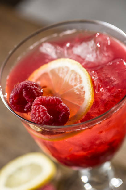 istock Alcoholic beverage with raspberries lemon and ice on bar counter in pub or restaurant 922744278