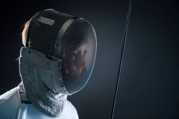 istock Boy wearing fencing mask against black background 922744820