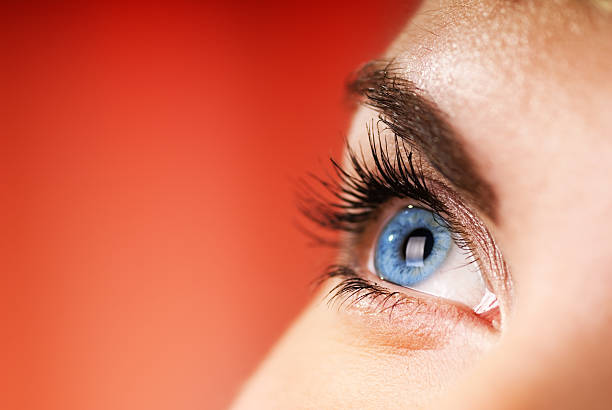 olho azul sobre fundo vermelho (dof raso - human eye eyesight women creativity imagens e fotografias de stock