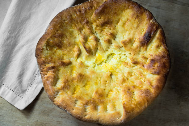 istock Scrumptious Appetizing Whole Round Flatbread with Cheese Filling on Wooden Table with White Cotton Napkin. Traditional Savory Pastry of Middle Eastern Oriental Mediterranean Indian Levantine Cuisines 922746952
