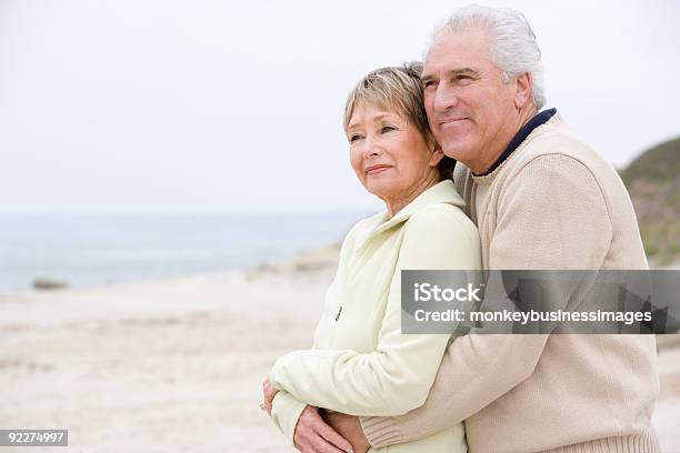 Foto de Casal Na Praia Abraçando E Sorrindo e mais fotos de stock de Apaixonar-se - Apaixonar-se, Casal Idoso, Praia