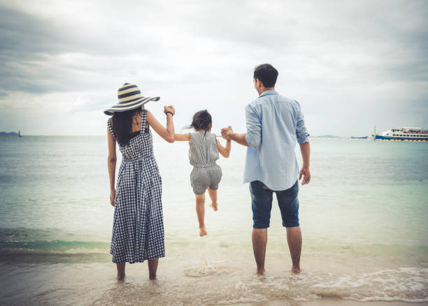 Portrait of happy family and baby enjoying sunset in the summer