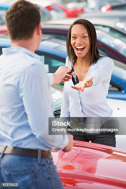 Donna Raccogliendo Chiavi Per Auto Nuova - Fotografie stock e altre immagini di Automobile - Automobile, Nuovo, Concessionaria automobilistica