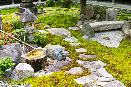 Morning detail on Zen garden in between Chion-ji Temple buildings walls. It is detail of Japanese type rock garden presenting miniature landscape. It is carefully arranged meditation place with rocks, water tank , moss, trees and on top the rock bridge over sand presenting water.