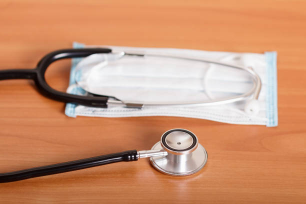 istock Diagnostic tool - phonendoscope and protective gauze mask, on wooden surface 922757680
