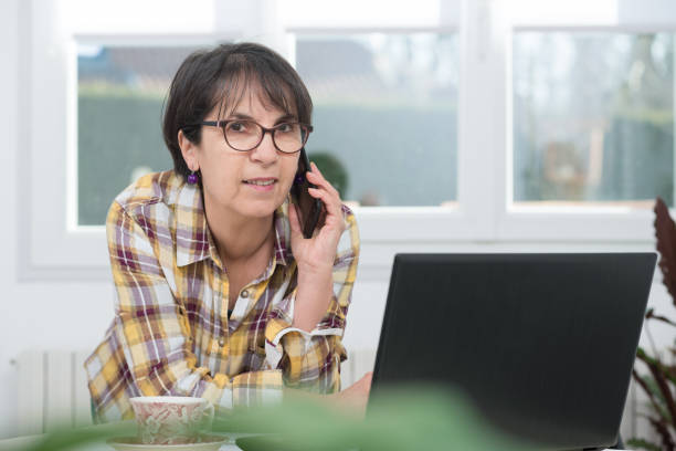 istock Smiling brunette senior woman using a smartphone 922757910