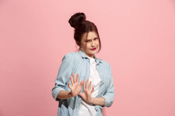 Let me think. Doubtful pensive woman with thoughtful expression making choice against pink background