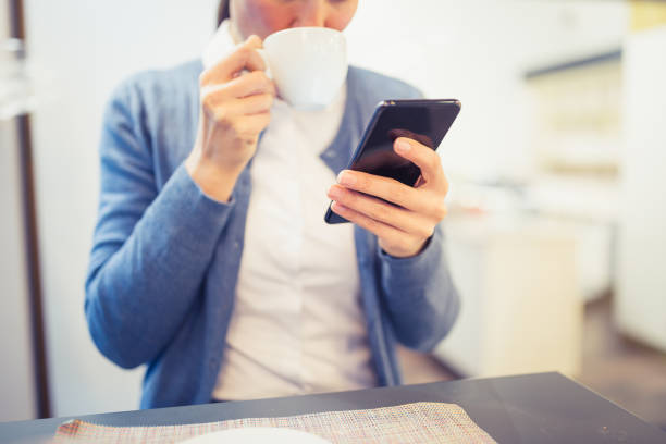 istock Cute woman drinking coffee, using mobile phone, sitting in cafe. Trieste, Italy 922759722
