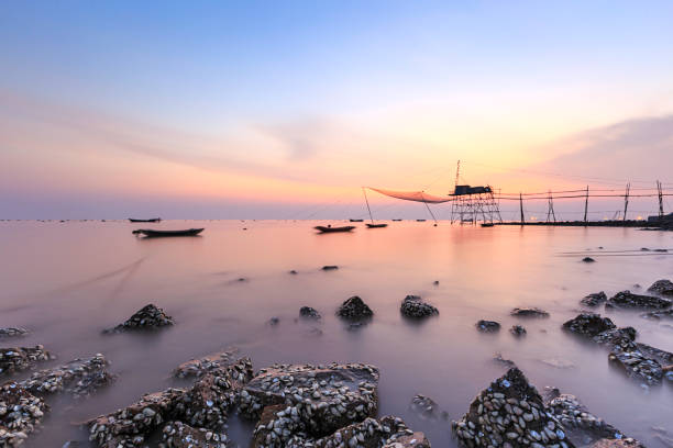 Silhouette Chinese Fishing Net At Sea Against pink Sky During Sunset,shanghai,china.