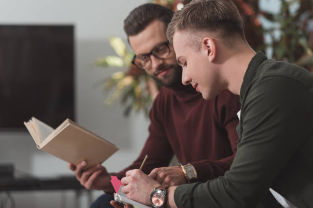 istock male friends studying together with notebook and book 922762244