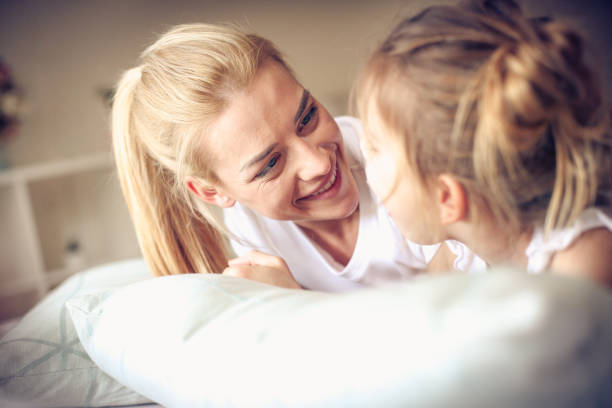 istock Happy middle age mother with her daughter lying on a bed. 922762278