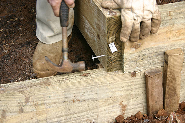 Hammering Large Nail into Wooden Garden Wall stock photo