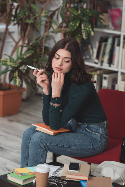 istock thoughtful student sitting on chair in library 922766400