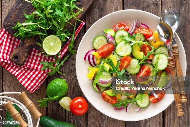 Healthy Vegetarian Dish Vegetable Salad With Fresh Tomato Cucumber Bell Pepper Red Onion Avocado And Arugula Stock Photo - Download Image Now