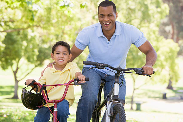 istock Man and young boy on bikes outdoors smiling 92276756