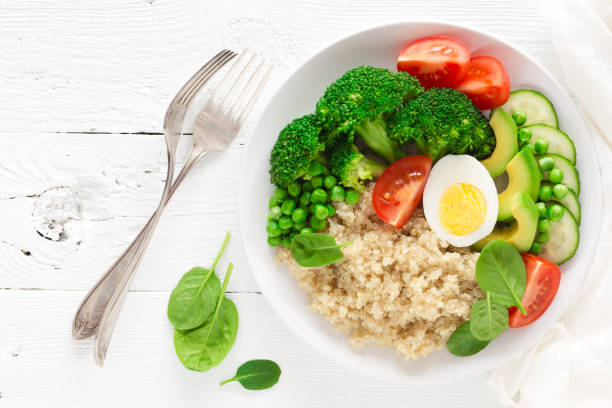 istock Healthy detox dish with egg, avocado, quinoa, spinach, fresh tomato, green peas and broccoli on white wooden background, top view 922767632