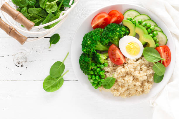 istock Healthy detox dish with egg, avocado, quinoa, spinach, fresh tomato, green peas and broccoli on white wooden background, top view 922767636