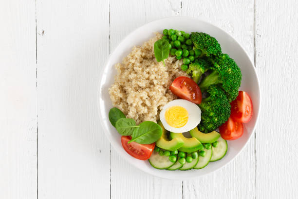 istock Healthy detox dish with egg, avocado, quinoa, spinach, fresh tomato, green peas and broccoli on white wooden background, top view 922767732