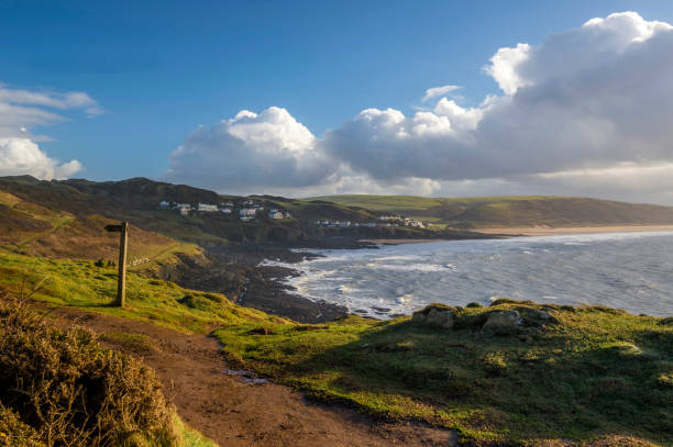 A winters walk from Mortehoe to Woolacombe Bay, featuring Mortehoe Peninsula, Bull Point Lighthouse, Morte Point, Lundy Isle, Morte Bay, Woolacombe Bay and Hartland Point across Barnstaple Bay between late afternoon and sunset with contrasting blue skies and wintery showers.  