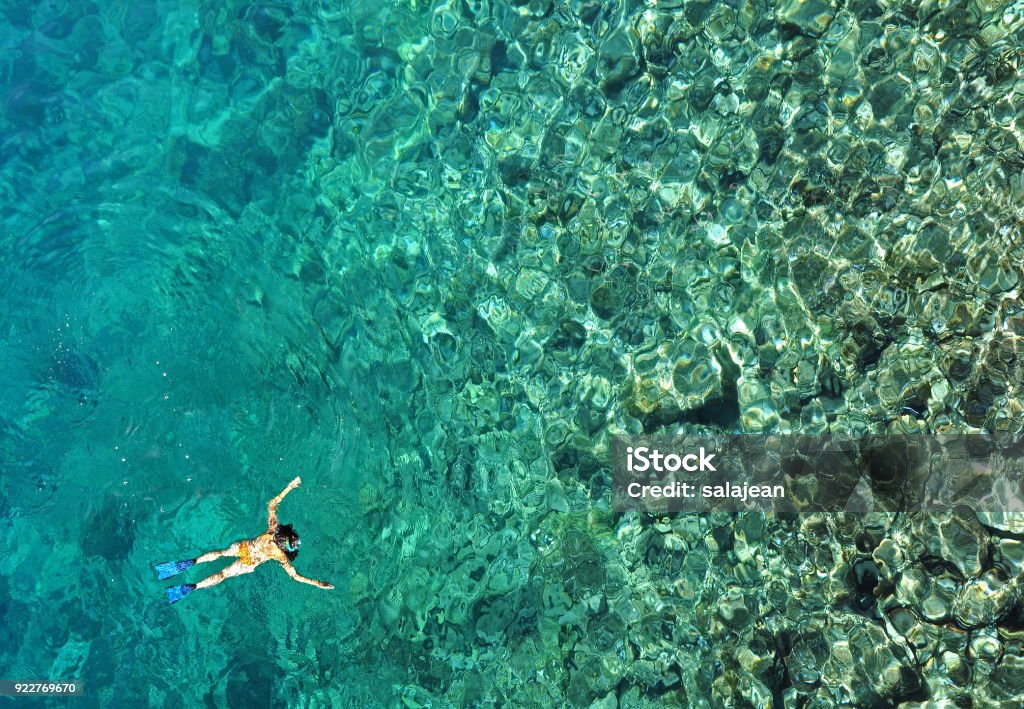 Woman snorkeling in sea water. Aerial view Aerial view of woman snorkeling in tropical sea water. Drone view Zanzibar Stock Photo