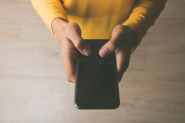 istock Woman standing and using smart phone on the floor at home 922770516