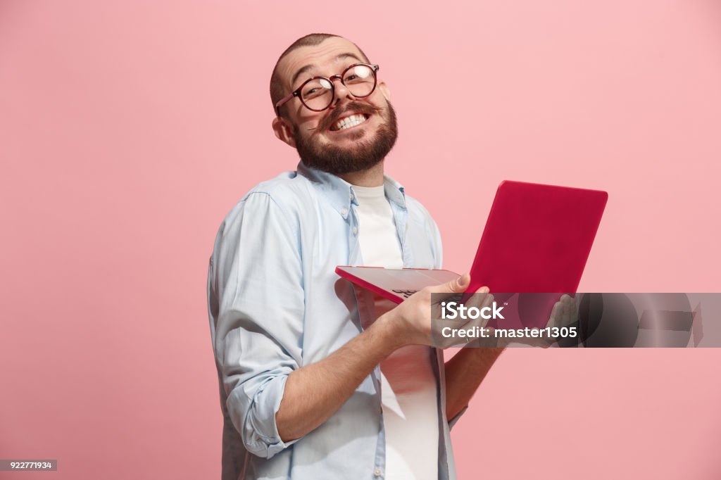 Businessman hugging laptop Businessman hugging laptop. Love to computer concept. Attractive male half-length front portrait, trendy pink studio backgroud. Young emotional bearded man. Human emotions, facial expression concept. Humor Stock Photo