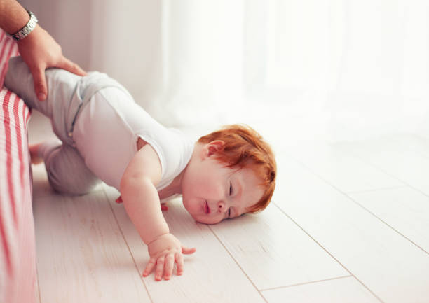 Poor little toddler baby fell down from the bed while crawling on it. Dad missed to catch him Poor little toddler baby fell down from the bed while crawling on it. Dad missed to catch him toddler hitting stock pictures, royalty-free photos & images