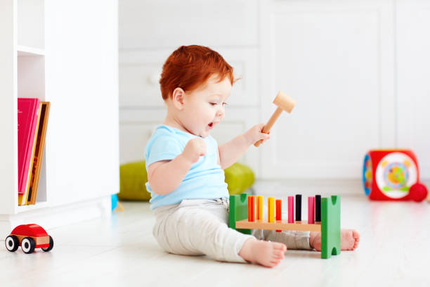 cute infant baby playing with wooden hammer block toy cute infant baby playing with wooden hammer block toy toddler hitting stock pictures, royalty-free photos & images